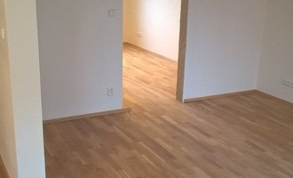 Vyrovnání výškových nerovností místností a pokládka masivní dřevěné podlahy lepením včetně lištování