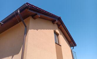Natření dřevěného podbití střechy.